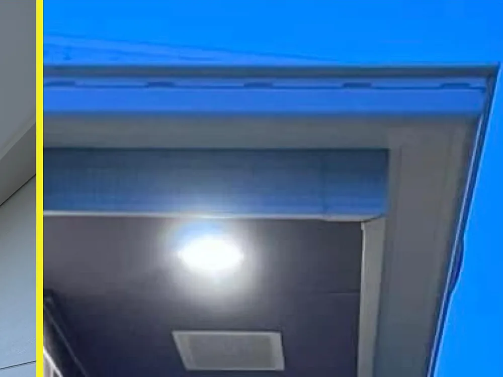 New LED downlight glowing under the eave of a brick home at dusk