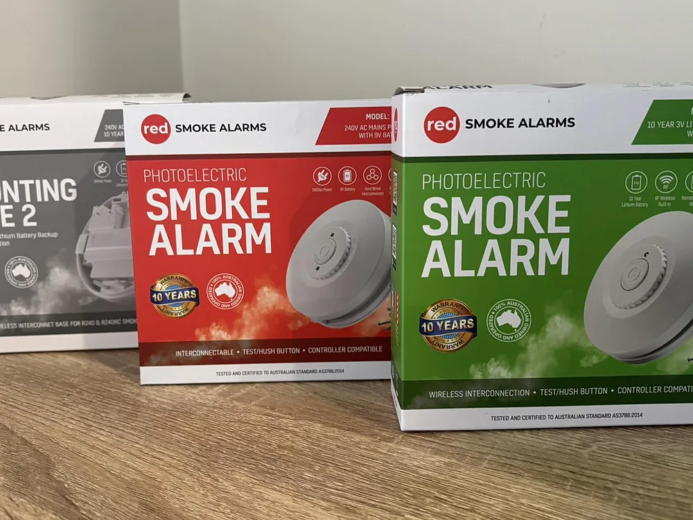 Boxes of photoelectric smoke alarms and a mounting base ready for installation