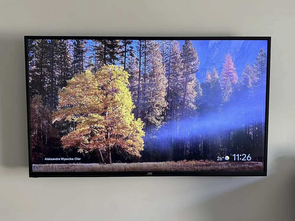 Large TV wall mounted level on a white wall with no cables showing