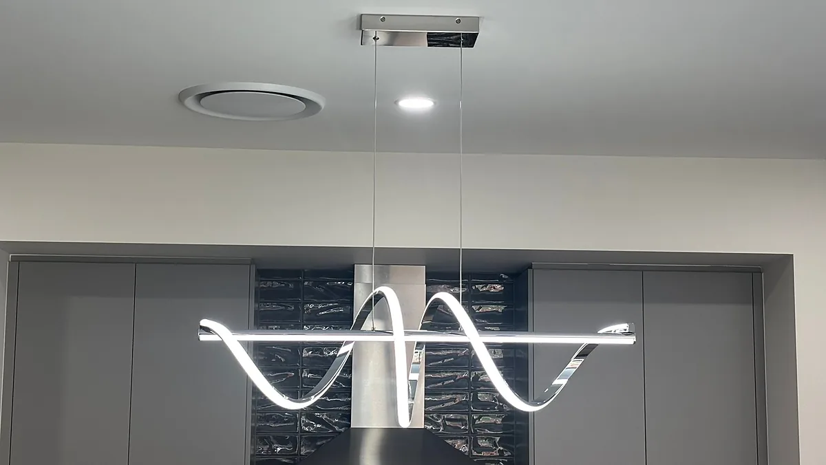 Wave shaped LED pendant light over a kitchen island